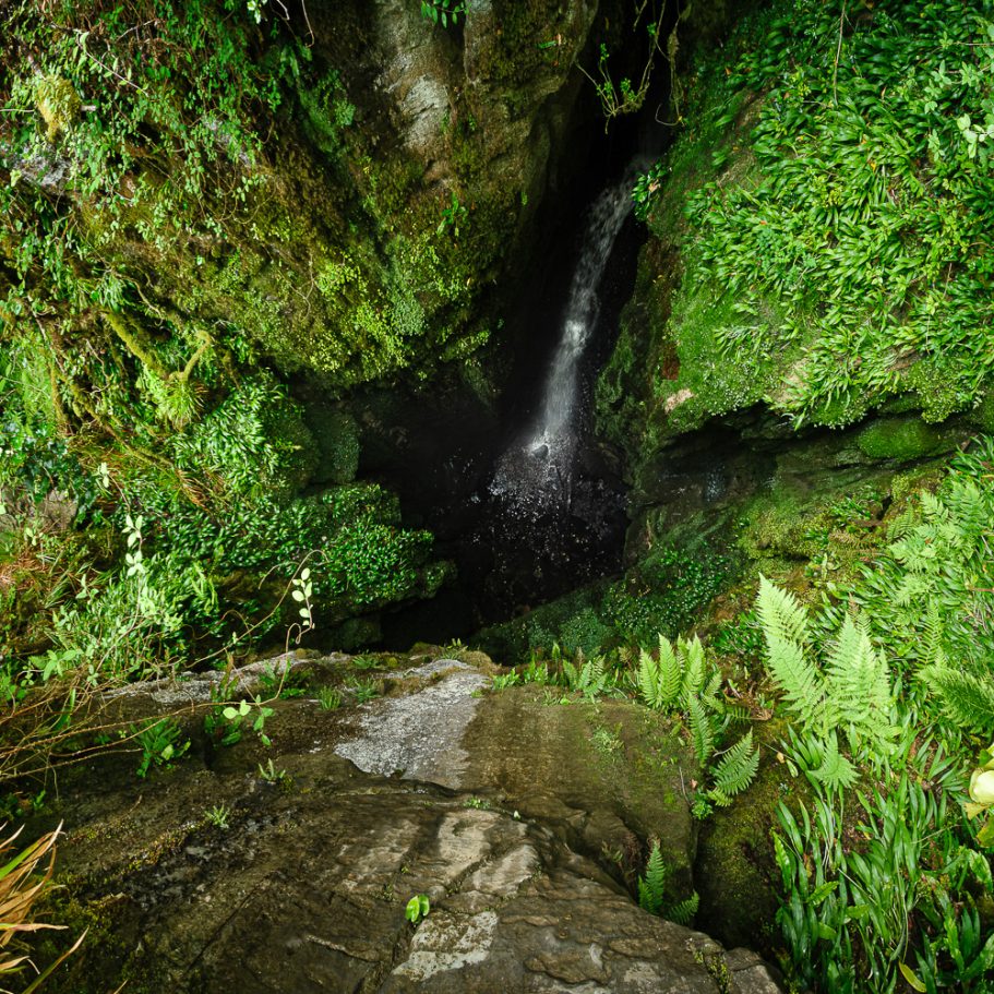 Pothole cave entrance with waterfall