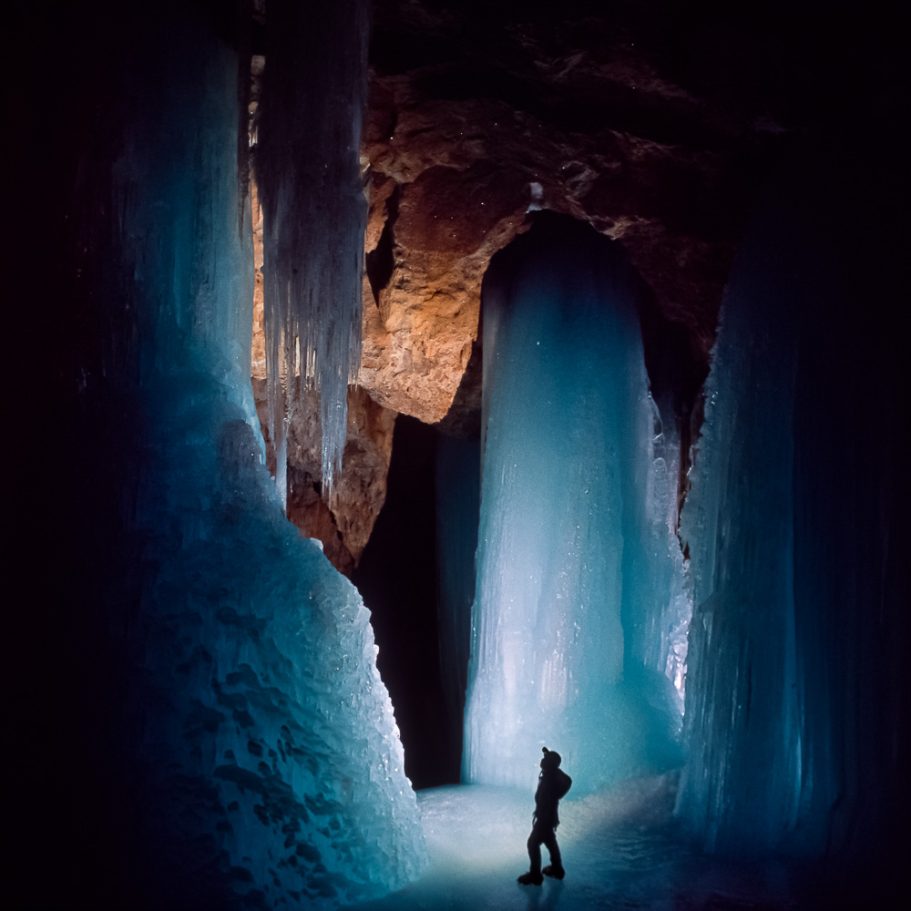 Caver surrounded by giant ice domes appearing blue in backlight