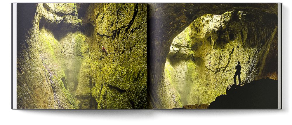 Sample double page of the 'Inside Mother Earth' book showing a caver abseiling into a vast daylight shaft