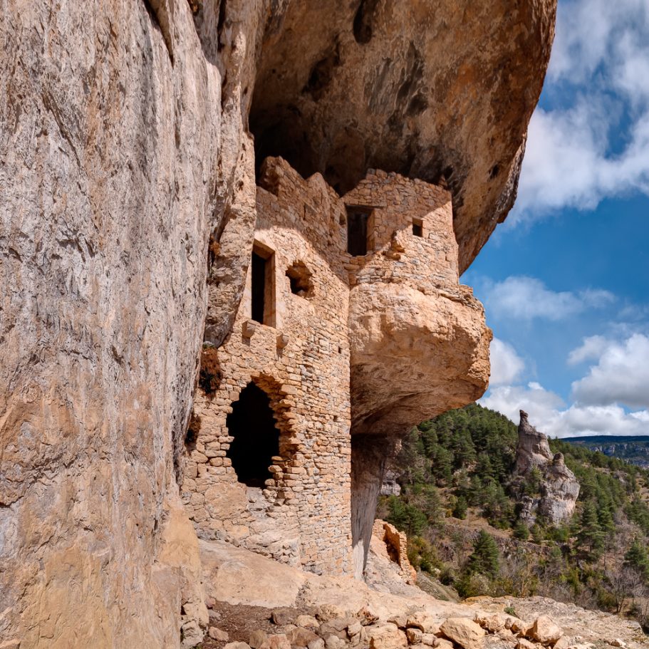 ruined walls with door and windows in a fortified cave entrance