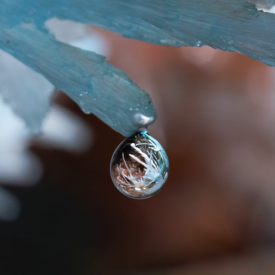 Water droplet forming at the tip of a bluish aragonite helictite