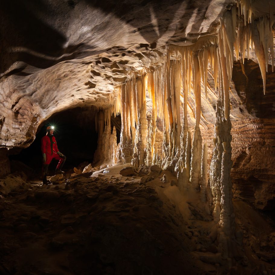 Caver admiring an array of stalactites and stalagmites