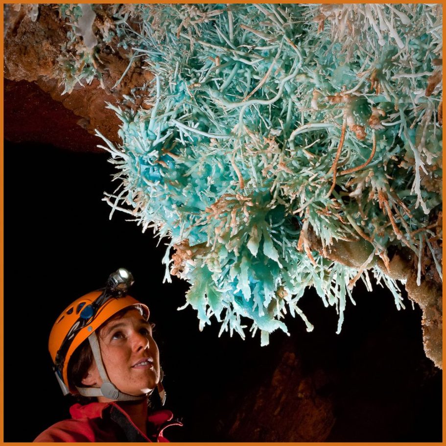 A caver admiring blue aragonite helicties in a cave in France; title photo for "French Jewels" portfolio