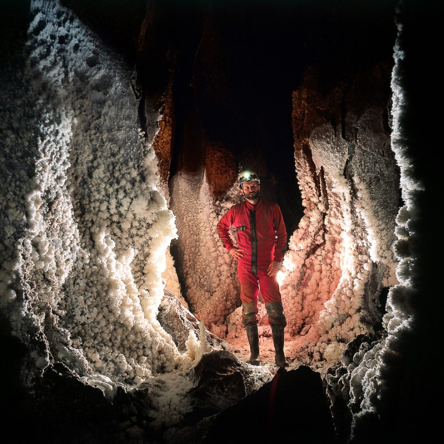 Caver in passage covered in aragonite speleothems
