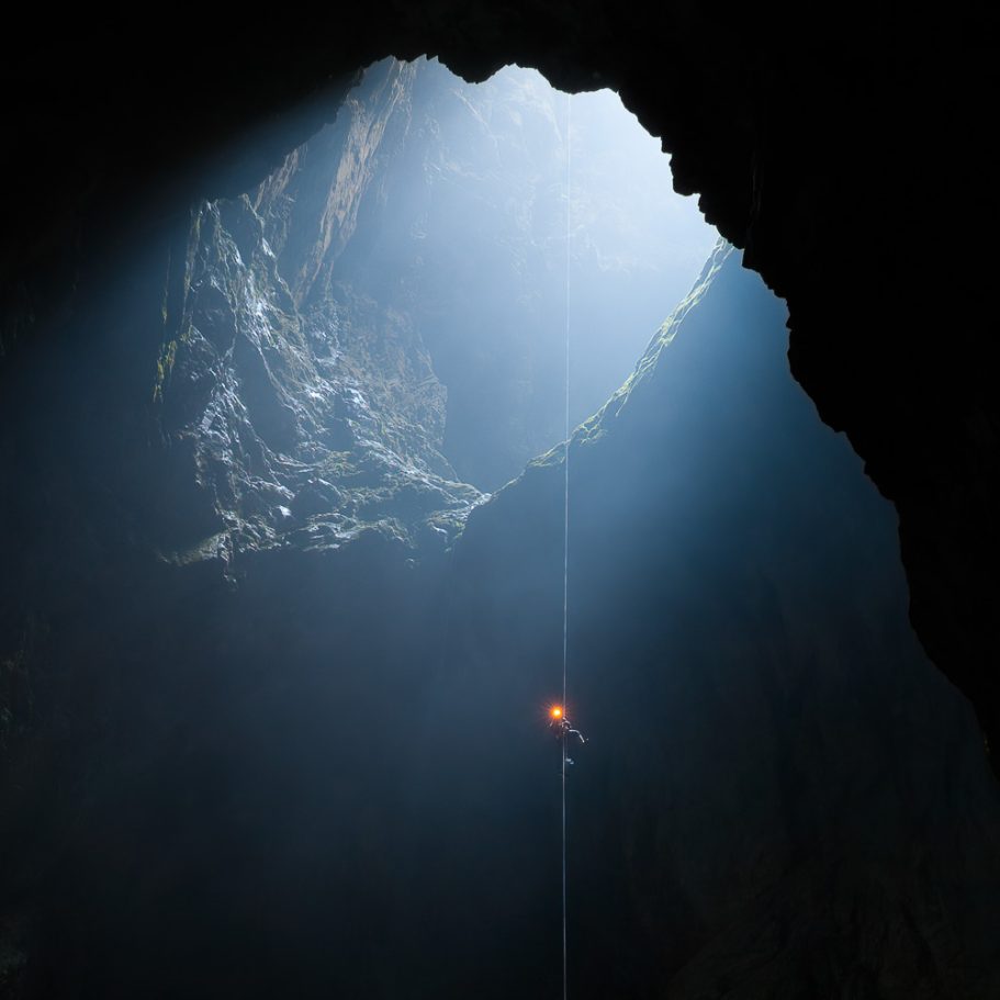 Caver abseiling a deep dayligth shaft