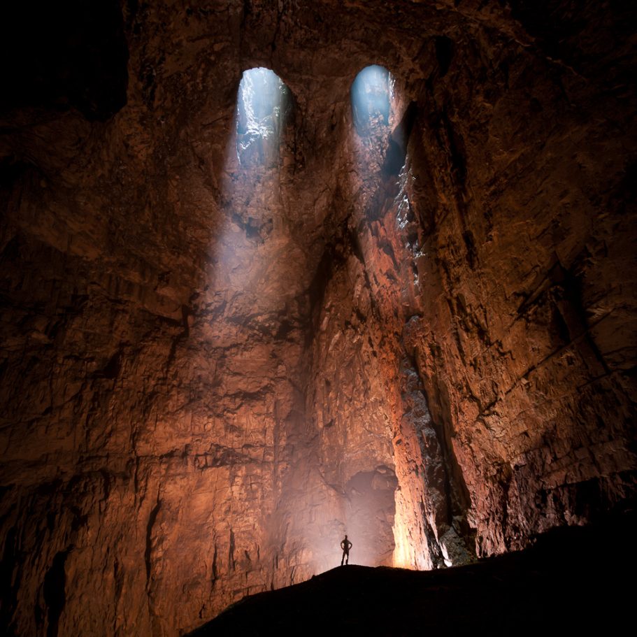 Caver below two skylights in the cave ceiling