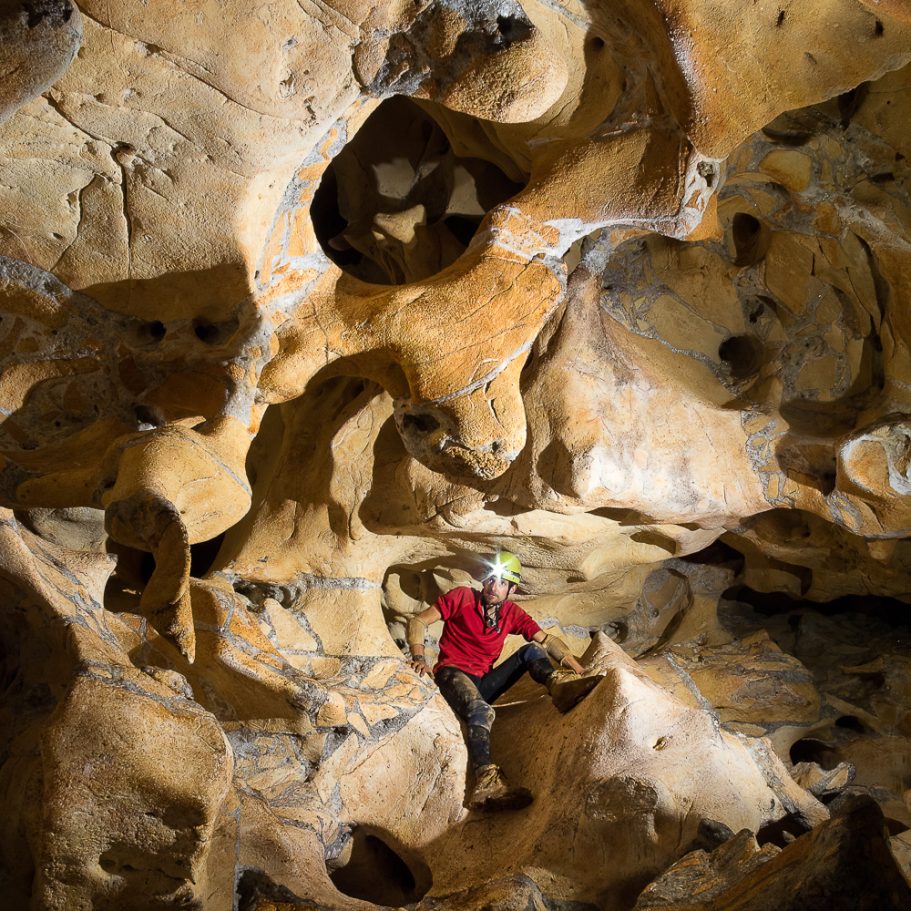 Caver in boneyard maze type cave passage