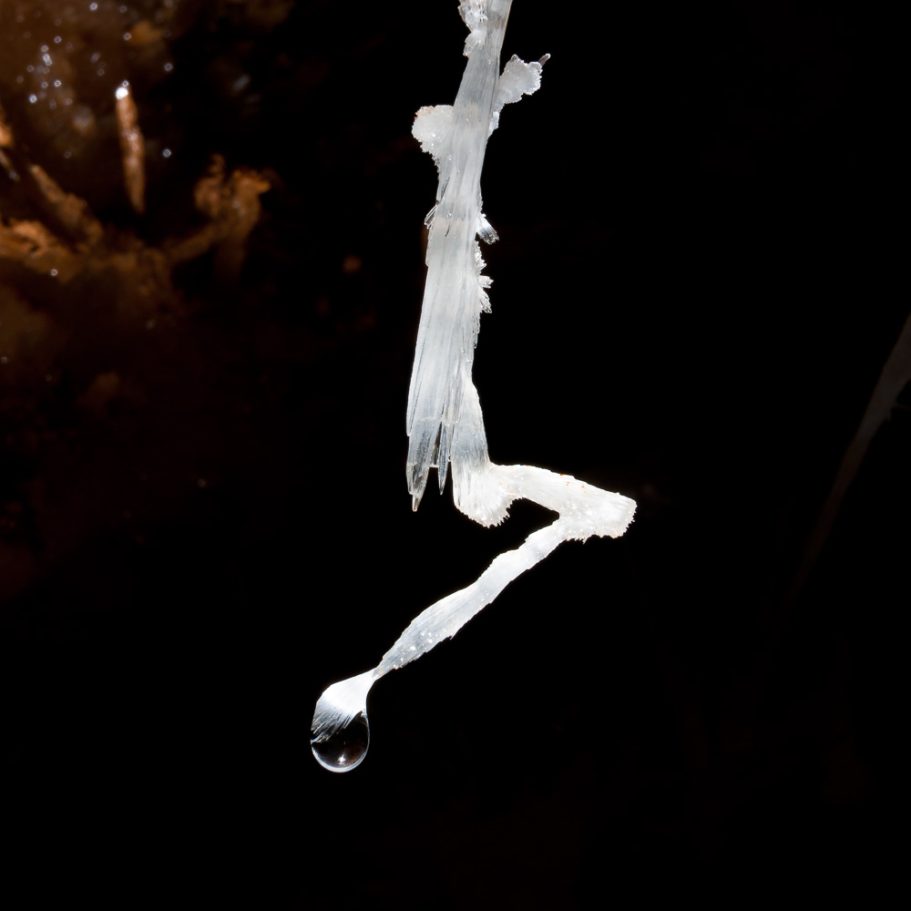 Zigzag-shaped helictite with water droplet at its tip