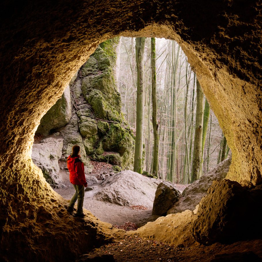 Caver in cicular cave entrance