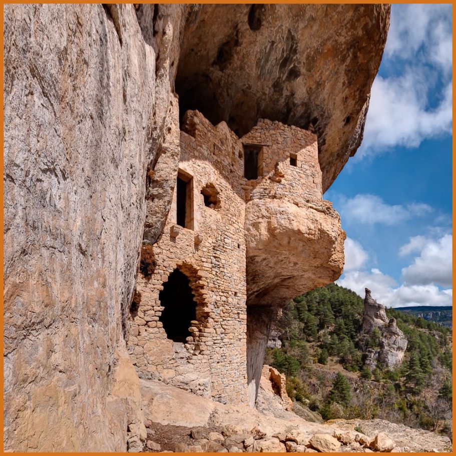 A cave entrance fortified with a ruined wall with doors and windows; title photo for "Human Factor" portfolio