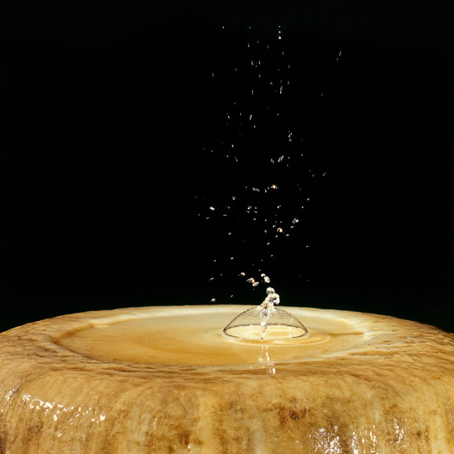 Dripping water creating a splash with air bubble on a stalagmite