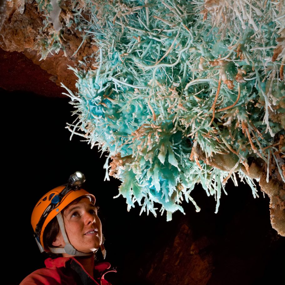 Caver looking at large cluster of blue aragonite helictites