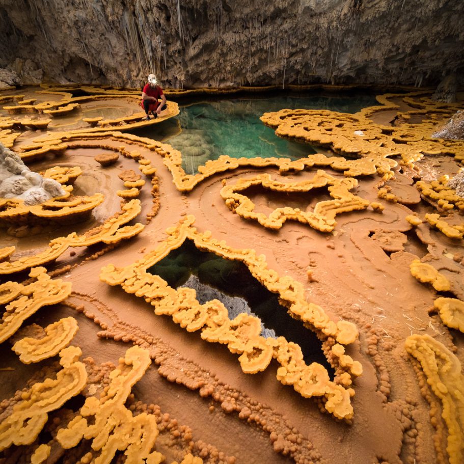 Caver looking at the delicate flowstone rims of 'Lake Castrovalva' in Lechuguilla Cave