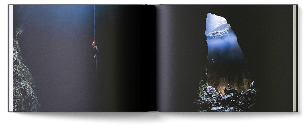 Sample double page of the 'New Zealand Karst' book showing a caver rapelling a deep pit