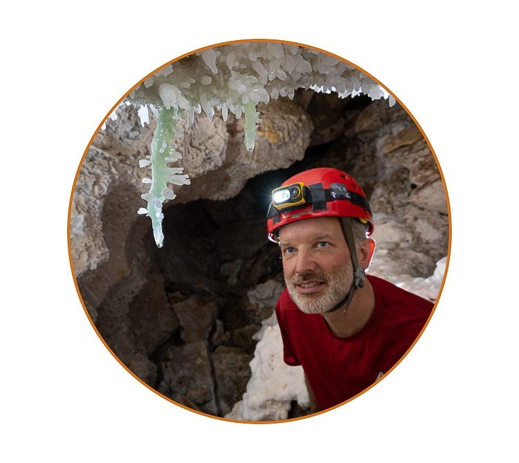 Max Wisshak admiring greenish barite stalactites in Lechuguilla Cave
