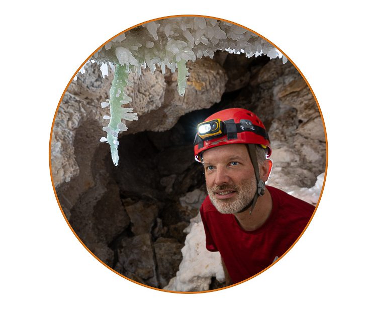 Max Wisshak admiring greenish barite stalactites in Lechuguilla Cave